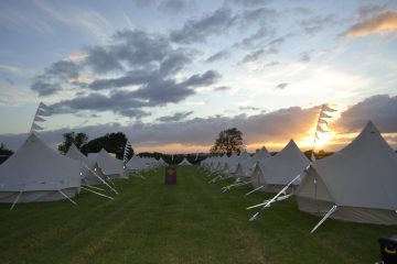 Long group of bell tents for friends at a music festival