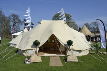 A front view of an emperor bell tent in a warm countryside