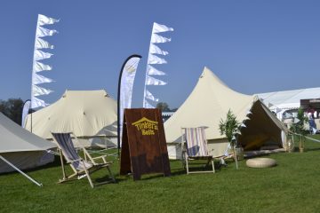 Bell Tents at a Wedding with flags in the blue sky